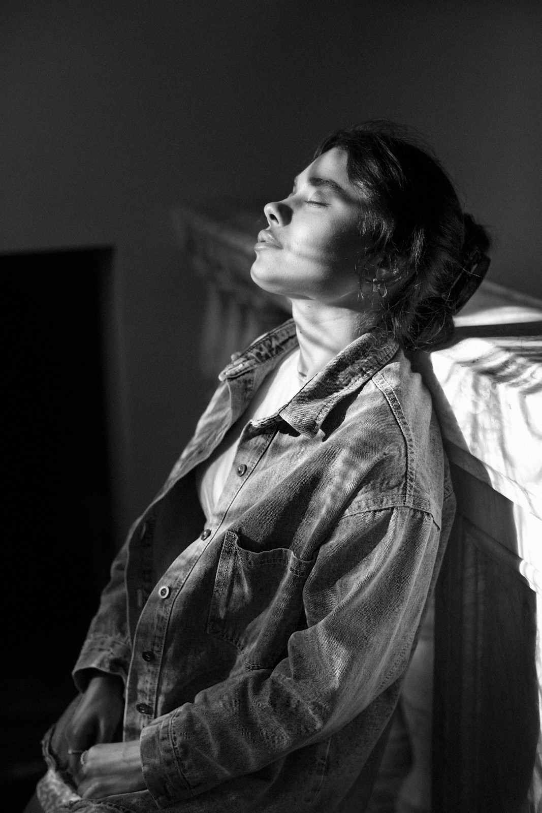 Woman pausing quietly, eyes closed, in soft window light